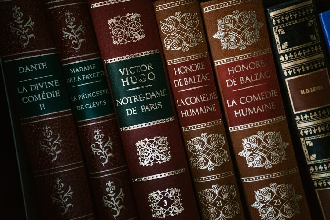Pila de libros antiguos encuadernados en cuero sobre una mesa de madera