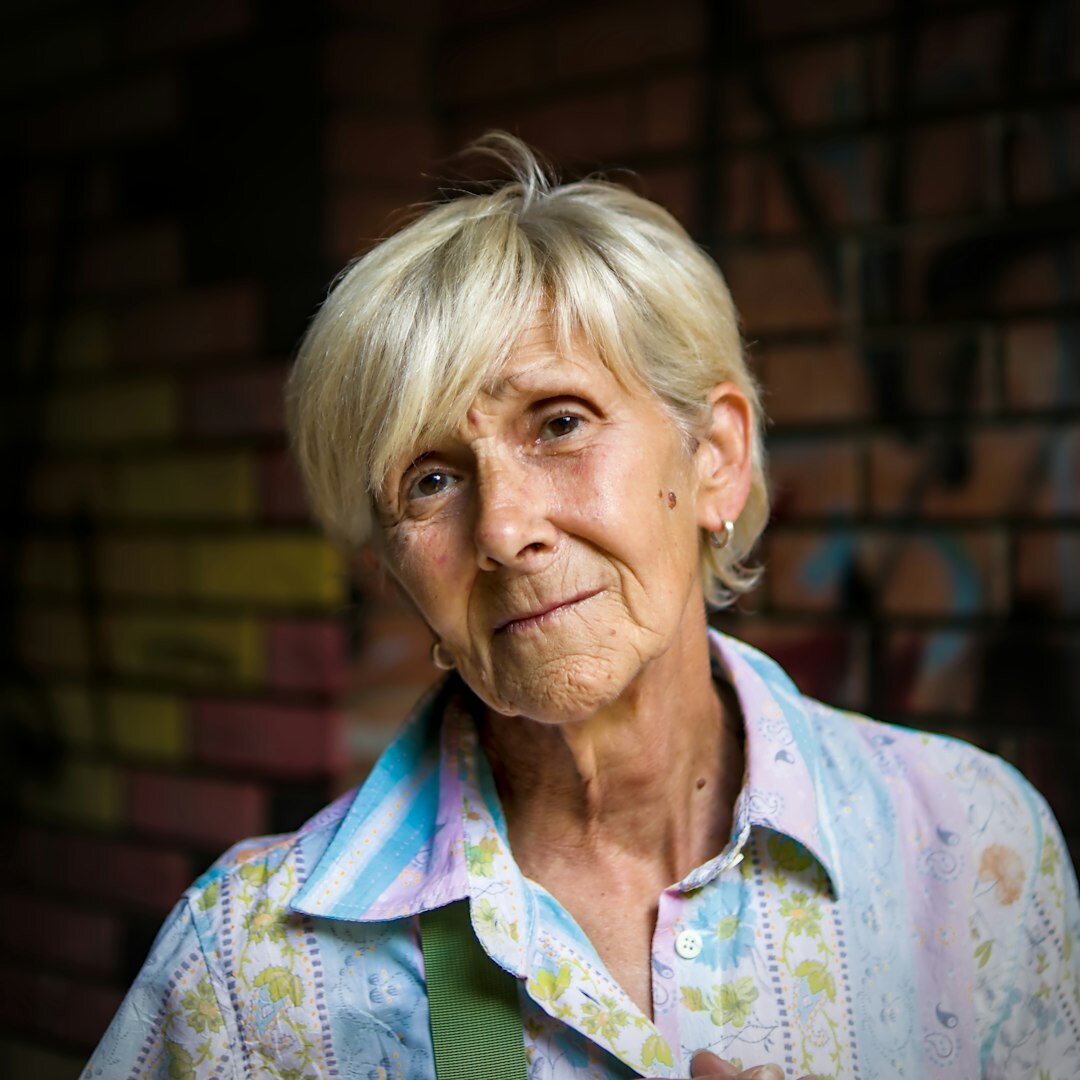 Mujer mayor con anteojos sonriendo, retrato de bibliotecaria