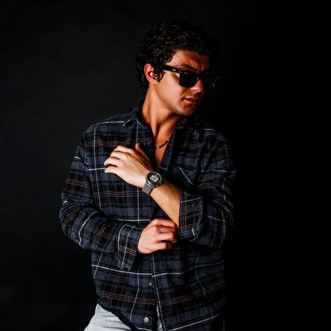 Hombre joven sonriendo con anteojos, retrato de estudio